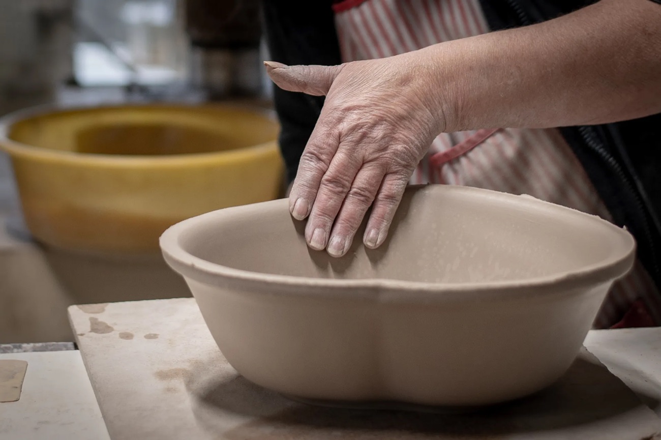 Les mains d'un potier façonnent un plat en argile
