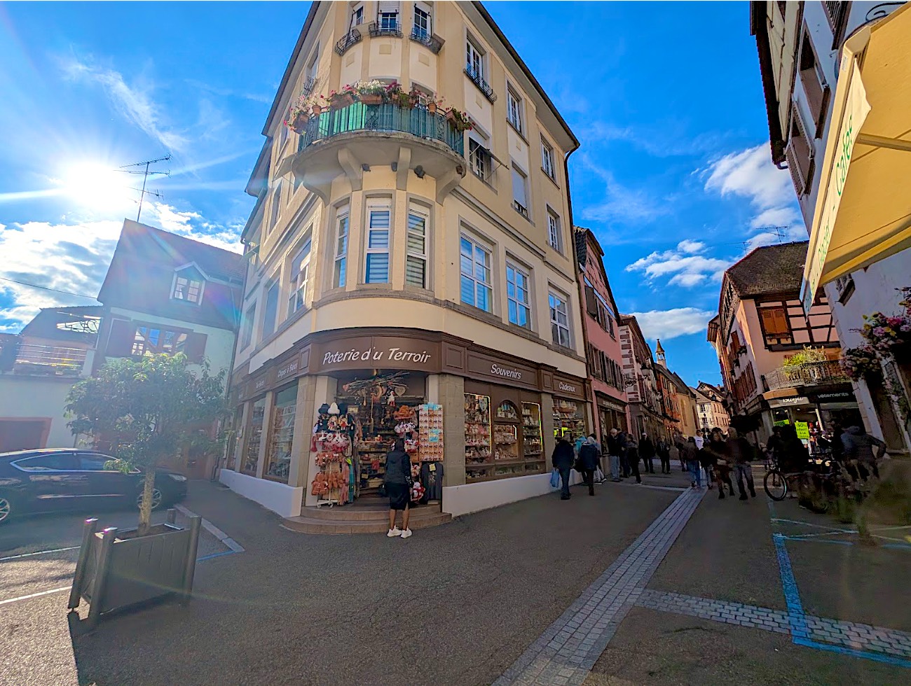 La boutique à l'angle de la Grand'Rue sous le soleil, balcon fleuri à l'étage